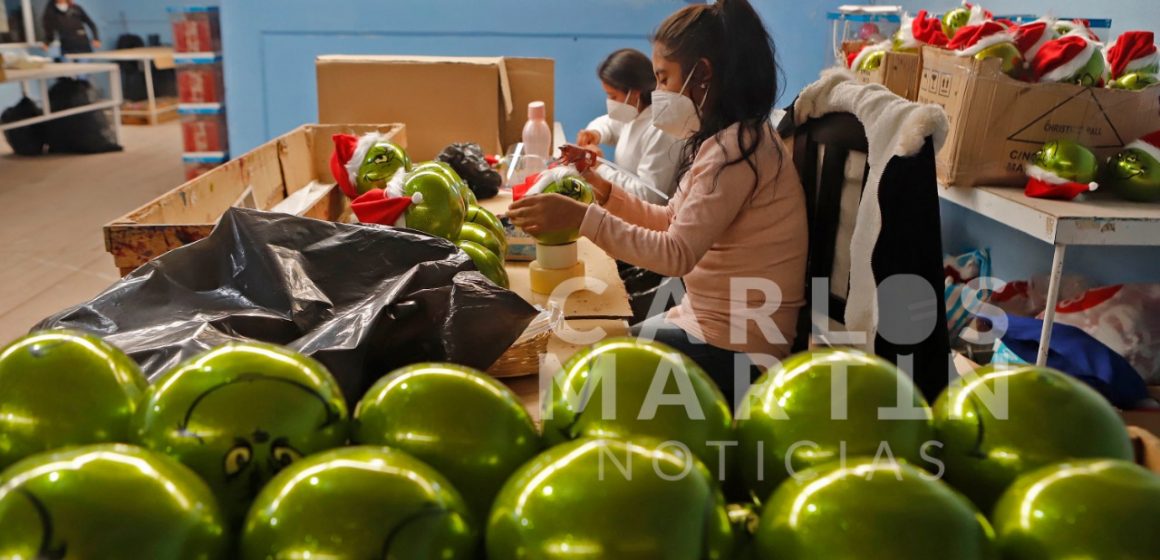 (FOTOS) Artesanos de Chignahuapan elaboran esferas de Navidad con la figura del grinch.