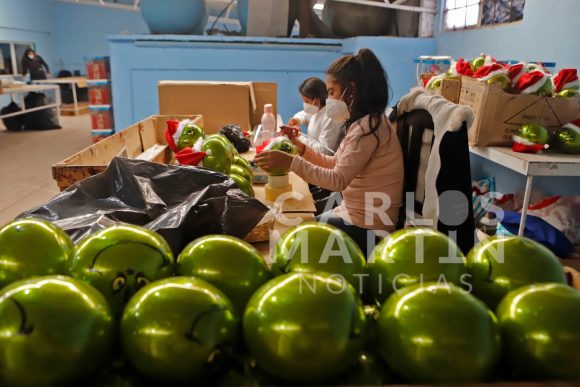 (FOTOS) Artesanos de Chignahuapan elaboran esferas de Navidad con la figura del grinch.