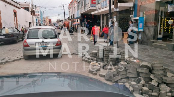 Automovilistas y transporte circulan sobre calles con adoquines amontonados en el Centro Histórico