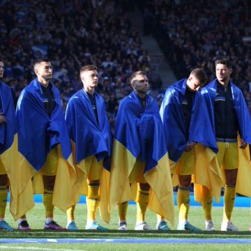 Selección ucraniana de futbol  se envuelven en su bandera durante el himno y piden alto a la guerra