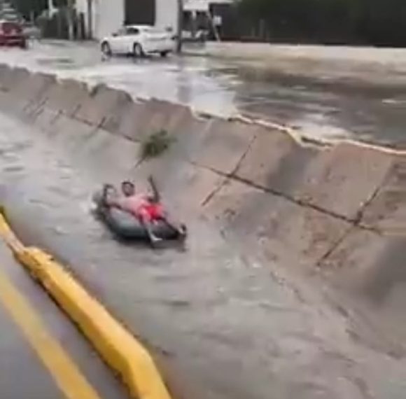 Hombre “navega” en colchón sobre canal de Chihuahua