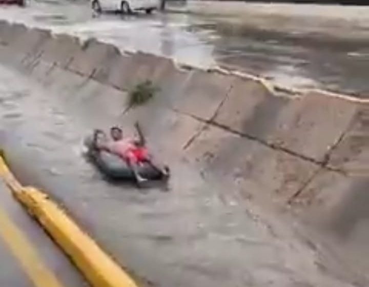 Hombre “navega” en colchón sobre canal de Chihuahua