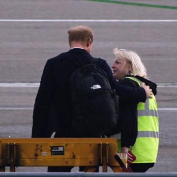 El Príncipe Harry es consolado por personal del aeropuerto al regresar de Balmoral
