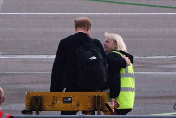 El Príncipe Harry es consolado por personal del aeropuerto al regresar de Balmoral