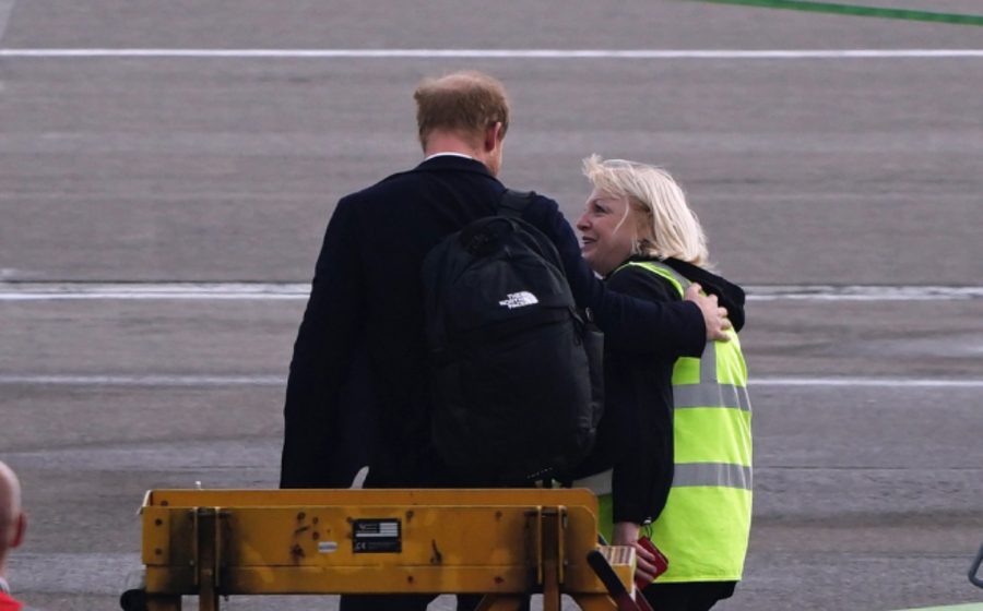 El Príncipe Harry es consolado por personal del aeropuerto al regresar de Balmoral