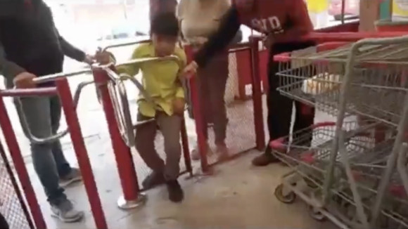 Travieso se atora en torniquete de tienda