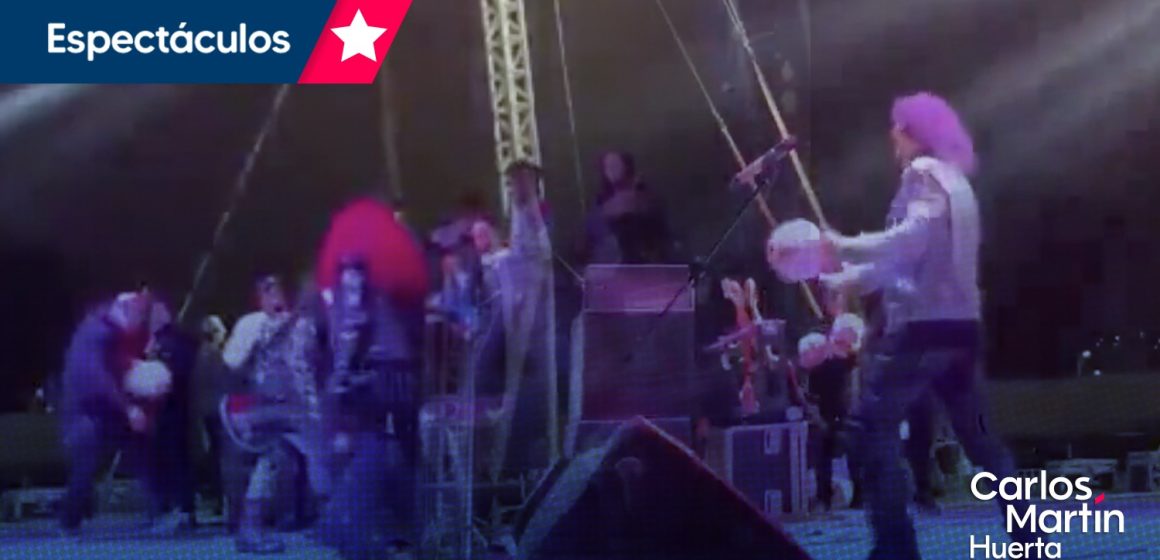 VIDEO Se cae Alex Lora en el escenario tras patear un balón