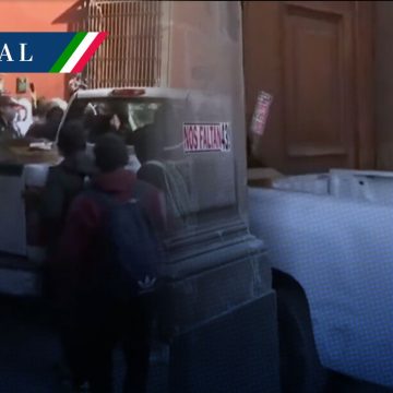 (VIDEO) Normalistas de Ayotzinapa derriban puerta de Palacio Nacional
